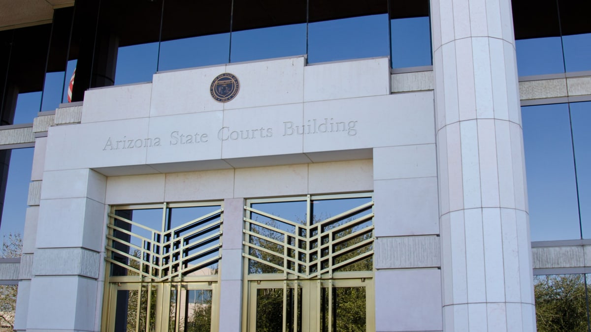 The entrance of the Arizona State Courts Building in Phoenix, with its name carved above glass doors