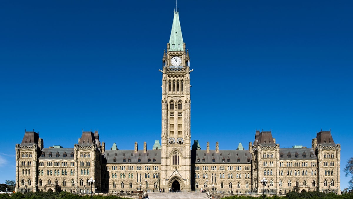 The Centre Block of Canada's Parliament buildings in Ottawa, with the Peace Tower clock rising against a clear blue sky