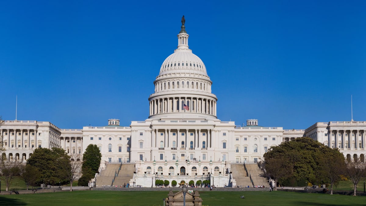 The west front of the U.S. Capitol in Washington, a white building with a large dome, under a clear blue sky