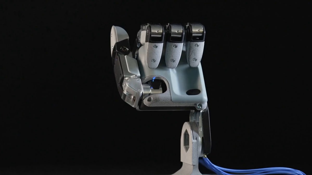 Boston Dynamics' Atlas robot holding a drill bit in one new four-finger hand and a power drill in the other