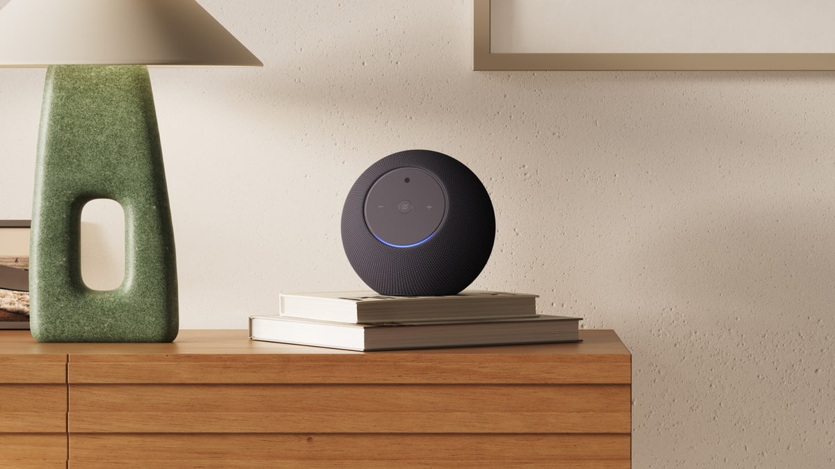 Amazon's Echo Studio speaker resting on a stack of books on a wooden dresser