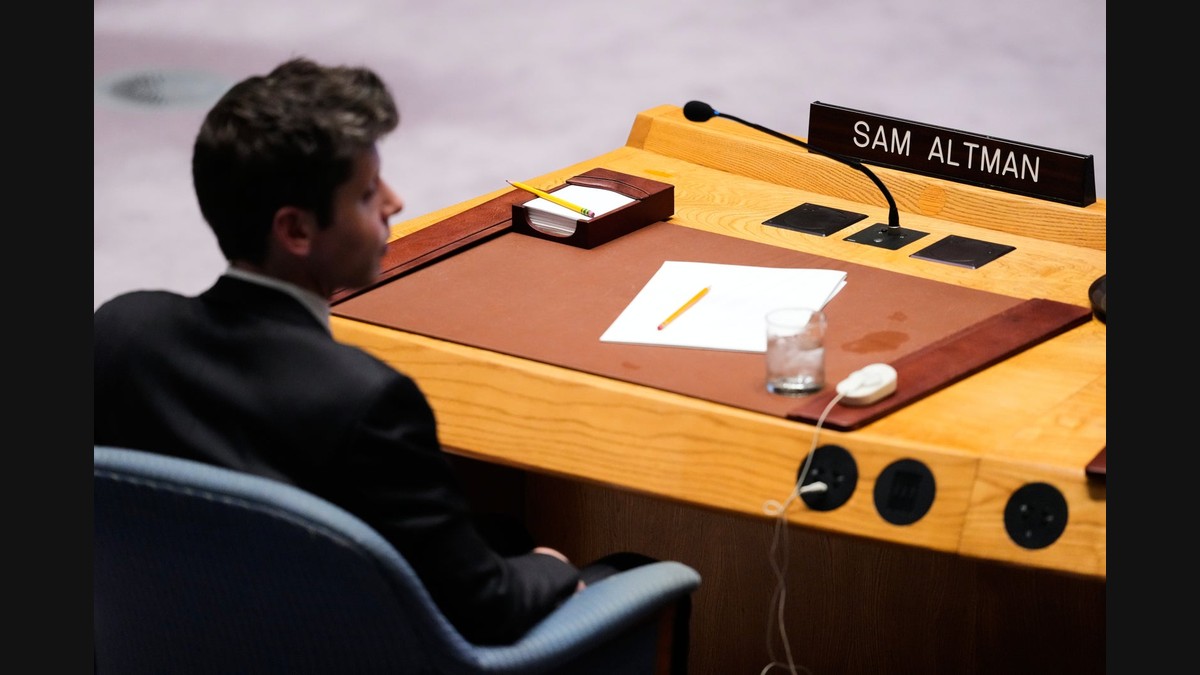 OpenAI CEO Sam Altman seated at a United Nations desk with a SAM ALTMAN nameplate
