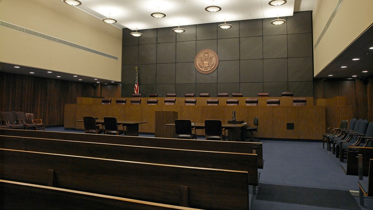 An empty courtroom in the James A. Byrne U.S. Courthouse in Philadelphia, with a long judges' bench beneath the U.S. seal