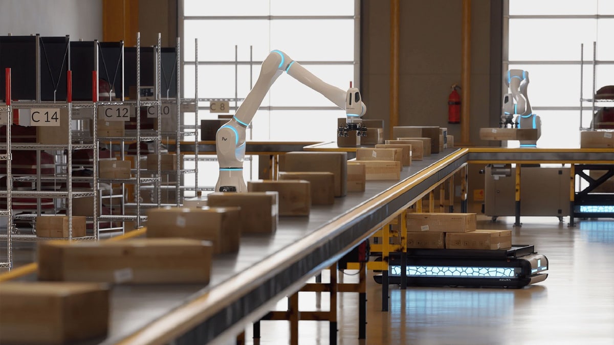 NEURA Robotics robot arms and a mobile robot moving boxes along a warehouse conveyor, the image Amazon used to announce its robot-building kit