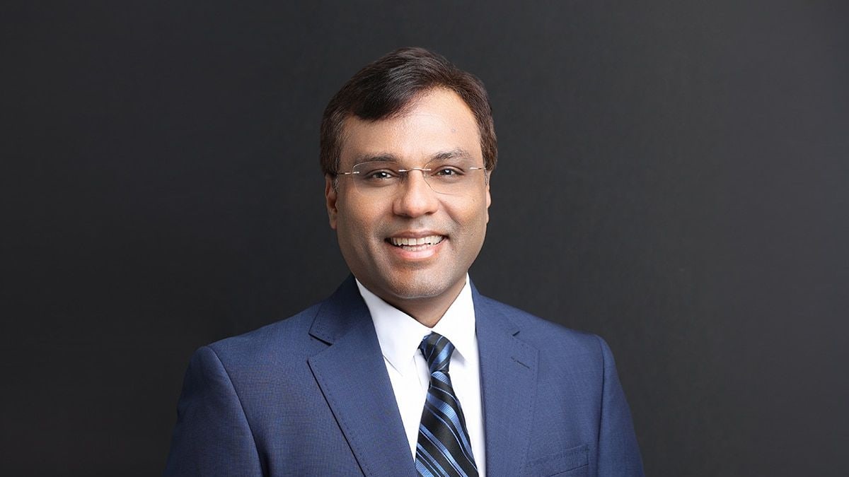 Portrait of Rohit Prasad, Boston Dynamics' new chief executive, in a blue suit against a dark background
