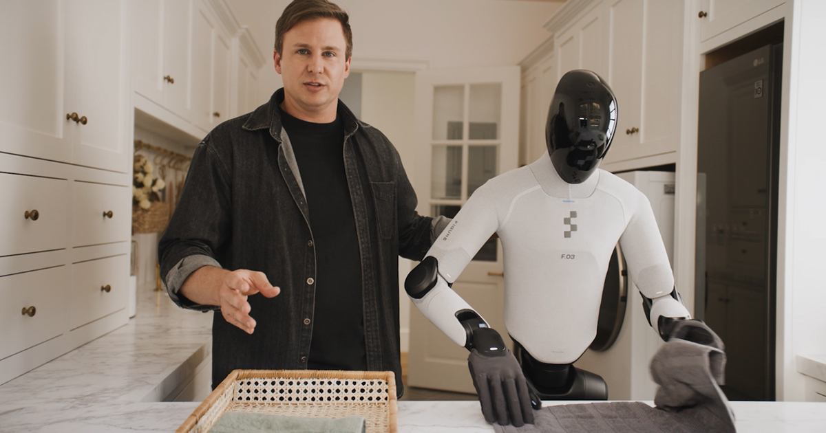 Official Figure Helix 2.5 announcement still: F.03 humanoid folding a towel in a home kitchen