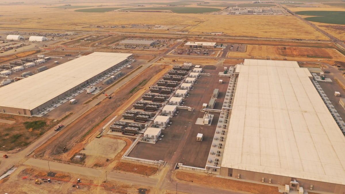 Aerial photo of Meta's data center in Kuna, Idaho: two long white-roofed buildings with rows of equipment between them, set in dry farmland