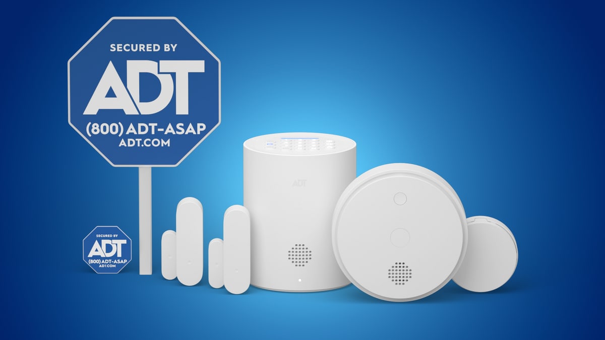 ADT's home security kit: a white base station with a keypad, door and window sensors, two round sensors and a blue Secured by ADT yard sign