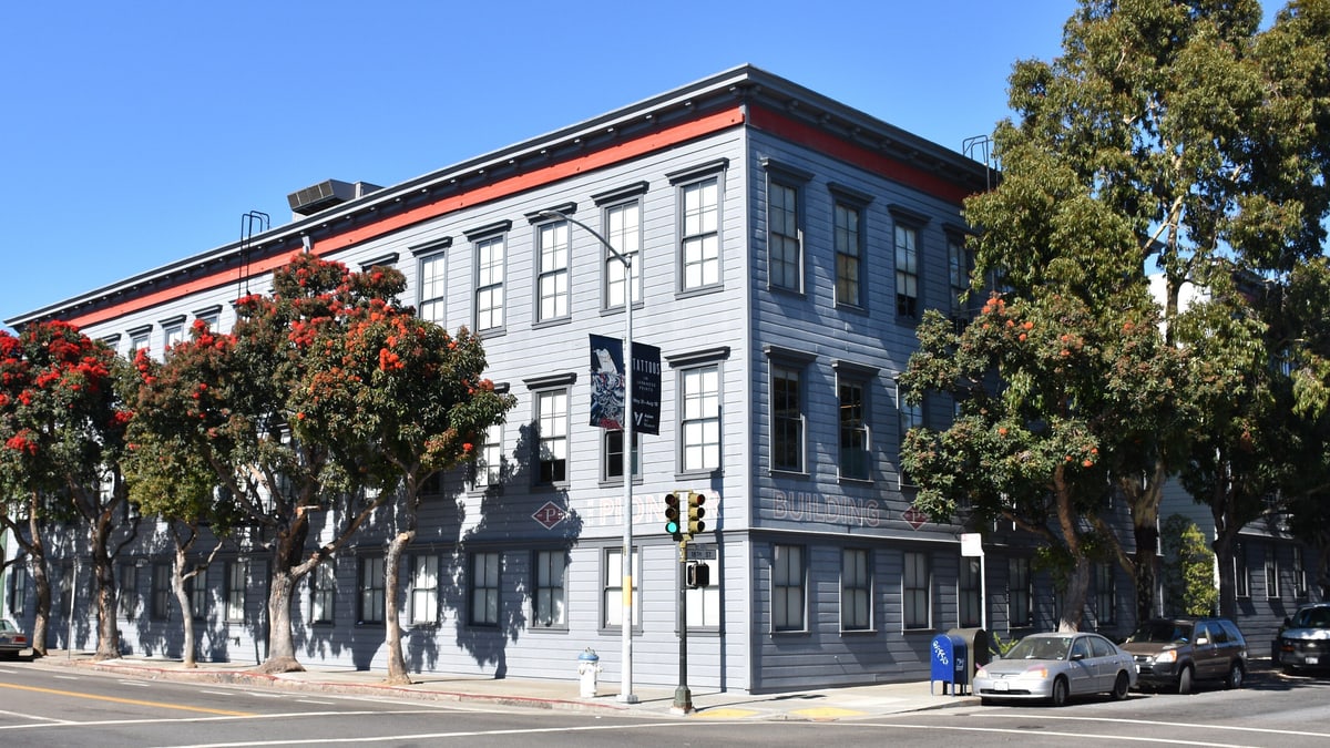 The Pioneer Building in San Francisco's Mission District, a grey office building on a street corner that housed OpenAI's offices in 2019