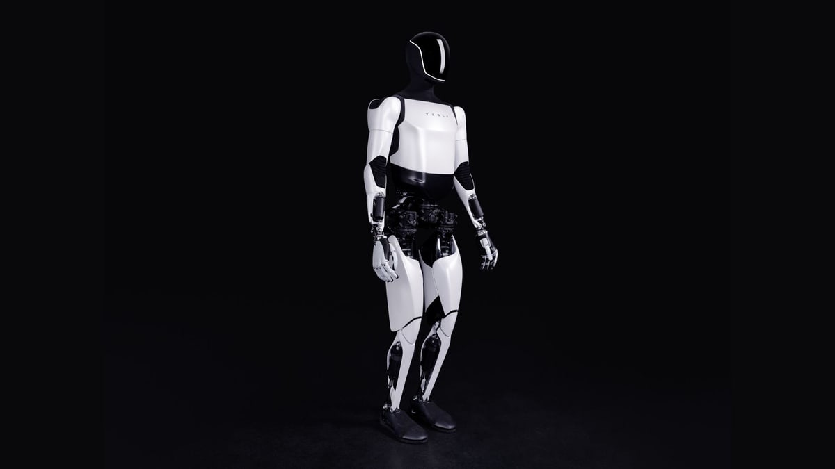 Tesla's Optimus humanoid robot, white and black, standing against a dark background