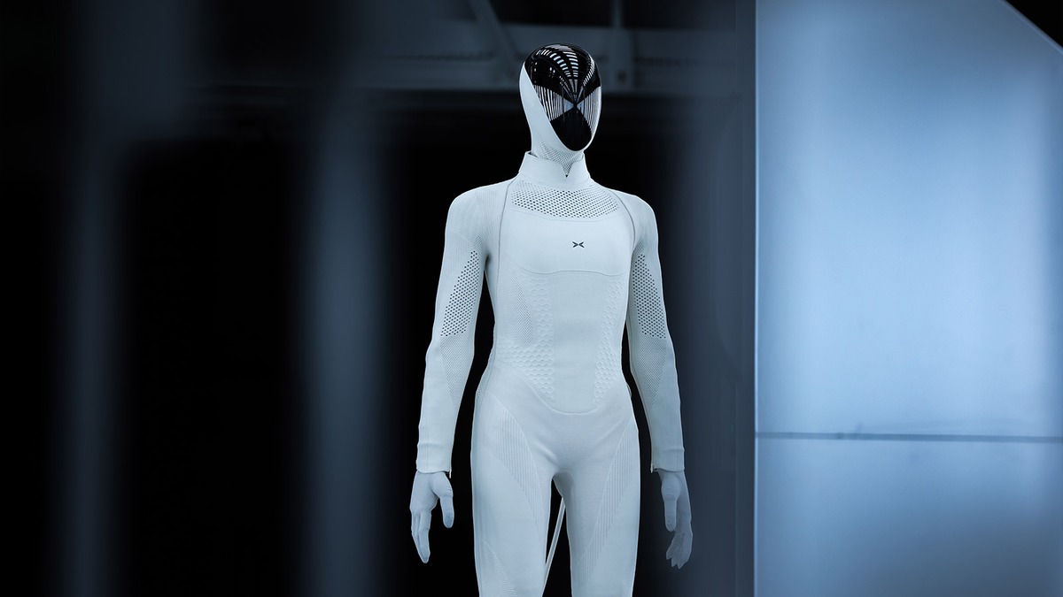 XPENG IRON humanoid robot standing at the company's manufacturing facility beside production equipment